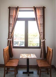 una mesa y dos sillas frente a una ventana en Hotel Hong Anh, en Phan Rang