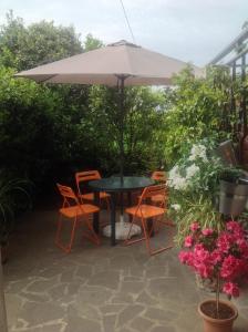 a table and chairs under an umbrella on a patio at Casa Giulia in Ronta