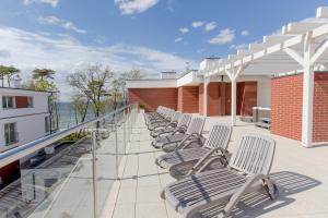 uma fila de cadeiras sentadas em cima de uma varanda em Resort Apartamenty Klifowa Rewal 4 em Rewal