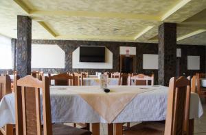 a dining room with a table and chairs and a tv at Pensiunea Nicol in Valea Iasului