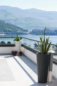a balcony with two potted plants and a view of the water at Arka Budva in Budva
