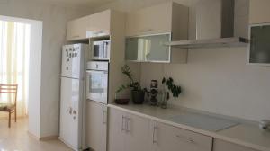 cocina con armarios blancos y nevera blanca en Apartment "Ostrova" en Kryzhanivka