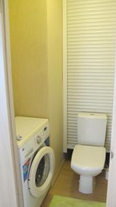 een badkamer met een toilet en een wasmachine bij Apartment "Ostrova" in Kryzhanivka
