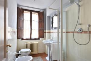 y baño con aseo, lavabo y ducha. en Tuscania Apartments, en Santa Croce sull'Arno