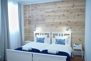ein Schlafzimmer mit einem weißen Bett und einer Holzwand in der Unterkunft Ribeira Funchal Center in Funchal