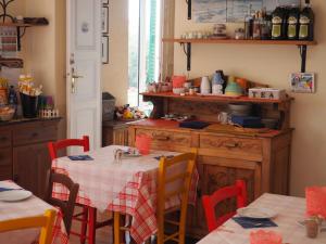 a kitchen with a table with red chairs and a table with a table cloth at hotel albatros in Arenzano