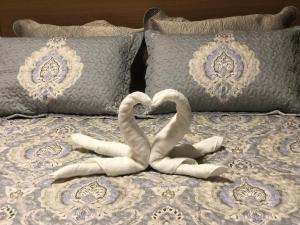 Dois cisnes de toalhas deitados numa cama com almofadas em Ondina Apart Hotel - Apto. 537 em Salvador