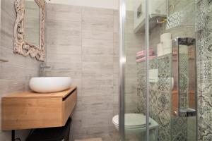 a bathroom with a sink and a glass shower at Main Square Apartments with sea view in Pula