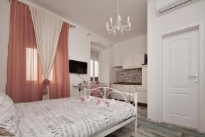 普拉Main Square Apartments with sea view的一间带床和枝形吊灯的白色卧室