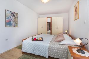 a bedroom with a bed with a tray on it at Apartments Alenka by the sea in Labin