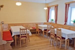 a dining room with tables and chairs and windows at Landhaus Essl in Dietach