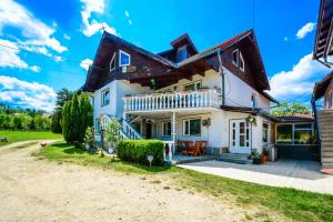 a large white house with a wooden roof at Pensiunea Iozefina in Moieciu de Jos
