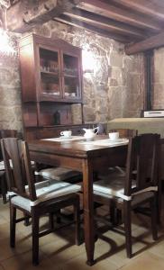 a wooden table and chairs in a room at A Lareira De Allariz in Allariz