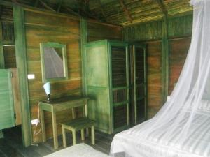 a bedroom with a bed and a table and a desk at Bahia Lodge in Capurganá