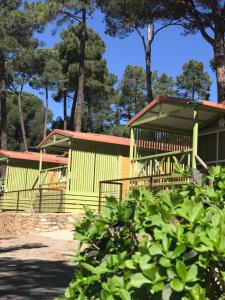 ein gelbes Gebäude mit Bäumen im Hintergrund in der Unterkunft Camping Resort-Bungalow Park Mas Patoxas in Pals