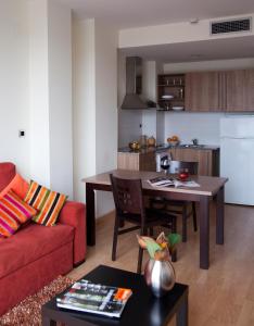 a living room with a red couch and a table at SG Costa Barcelona Apartments in Castelldefels