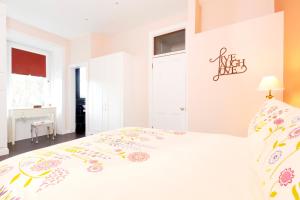 a white bedroom with a white bed with flowers on it at Edinburgh Near Centre Luxury Apartment in Edinburgh