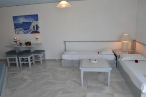 a living room with two beds and a table at Futura Hotel in Maleme