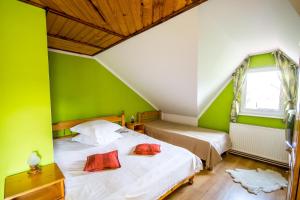 two beds in a room with green walls at Pensiunea Iozefina in Moieciu de Jos