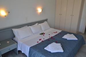 a bedroom with a bed with red roses on it at Futura Hotel in Maleme