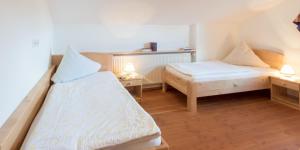 um quarto com duas camas e duas mesas com candeeiros em Pension Zum Ebenstein am Donausteig em Untergriesbach