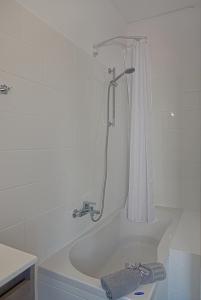 a bathroom with a bath tub with a shower curtain at Serene Sea View Apartment in Corfu Old Town in Corfu +21 photos