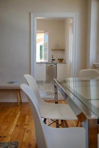 a dining room with a glass table and white chairs at Serene Sea View Apartment in Corfu Old Town in Corfu Town