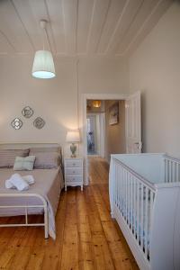a bedroom with a white bed and a crib at Serene Sea View Apartment in Corfu Old Town in Corfu