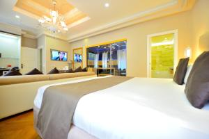 sypialnia z dużym białym łóżkiem i kanapą w obiekcie Terrazza Marco Antonio Luxury Suite w Rzymie