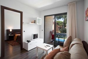 een woonkamer met een bank, een tafel en een spiegel bij SG Marina 54 Apartments in Castelldefels