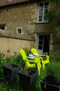 ÉcommoyにあるMaison de vacancesの黄色い椅子2脚と家の前のテーブル