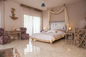sypialnia z dużym łóżkiem i 2 krzesłami w obiekcie Argo Summer House w mieście Áyioi Apóstoloi