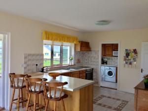 a kitchen with a counter and chairs in it at Sheila's View - Spanish Point, Co. Clare in Spanish Point