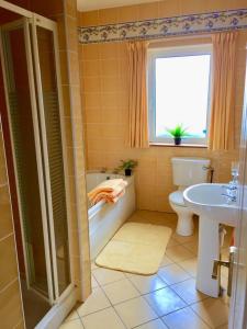 łazienka z wanną, toaletą i umywalką w obiekcie Sheila's View - Spanish Point, Co. Clare w mieście Spanish Point
