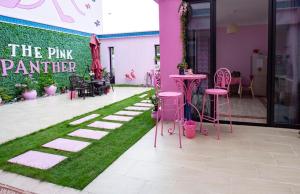 różowa impreza panter z różowymi stołami, krzesłami i trawą w obiekcie Vanke Shuangyue Bay Villa w mieście Huidong