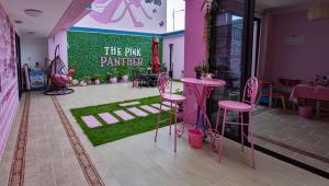 una habitación con taburetes rosas y un cartel de pantera rosa en Vanke Shuangyue Bay Villa, en Huidong