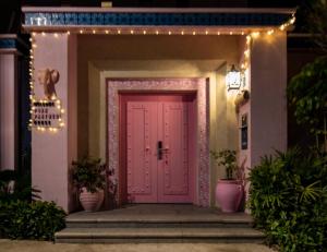 a pink door on a house with lights at Vanke Shuangyue Bay Villa in Huidong