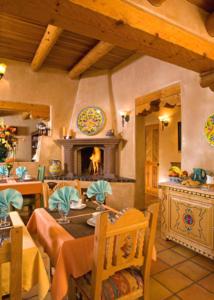 comedor con mesa y chimenea en El Farolito B&B Inn, en Santa Fe
