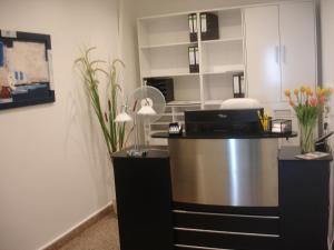 a kitchen with a desk with a lamp and flowers at City-Pension-Dortmund in Dortmund