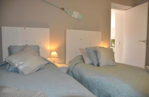 two beds sitting next to each other in a bedroom at Aquamarine - Gemstone Getaway in Vale do Lobo