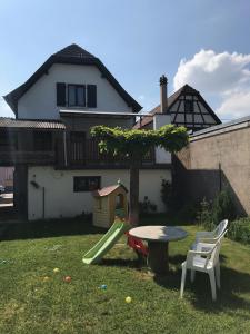 un parque infantil con una mesa y un tobogán en un patio en Gite chez Annette et Pierre Weber en Niedernai