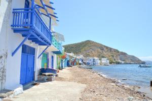 une plage avec des bâtiments colorés et l'eau dans l'établissement Blue Sea House, à Klima