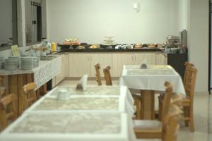 cocina con mesa, sillas y barra en Al-Manara Hotel, en São Borja