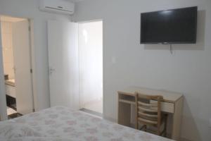 Schlafzimmer mit einem Schreibtisch und einem TV an der Wand in der Unterkunft Al-Manara Hotel in São Borja
