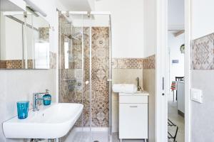 bagno bianco con lavandino e doccia di Casa Vacanze "Oceano mare" a Pozzallo