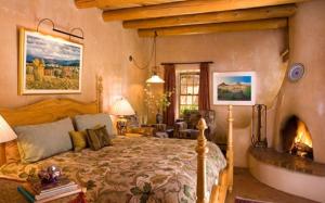 1 dormitorio con 1 cama grande y chimenea en El Farolito B&B Inn, en Santa Fe