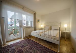 a bedroom with a bed and a large window at Apartments Vila Marjetica in Bled