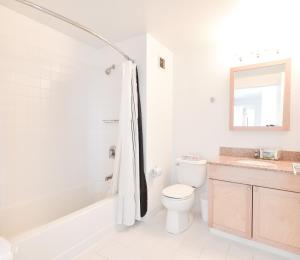 Baño blanco con aseo y lavamanos en Global Luxury Suites at Kendall West, en Cambridge