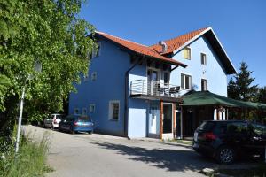 a blue and white house with cars parked on the street at Apartments Blue House in Zlatibor