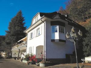 ein weißes Haus mit einem Fenster und einem Straßenlicht in der Unterkunft Landhaus am Sonnenberg in Bad Bertrich